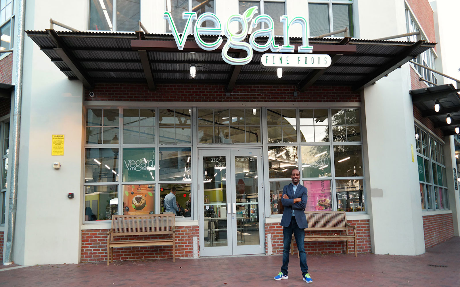 Founder of Vegan Fine Foods standing in front of his store
